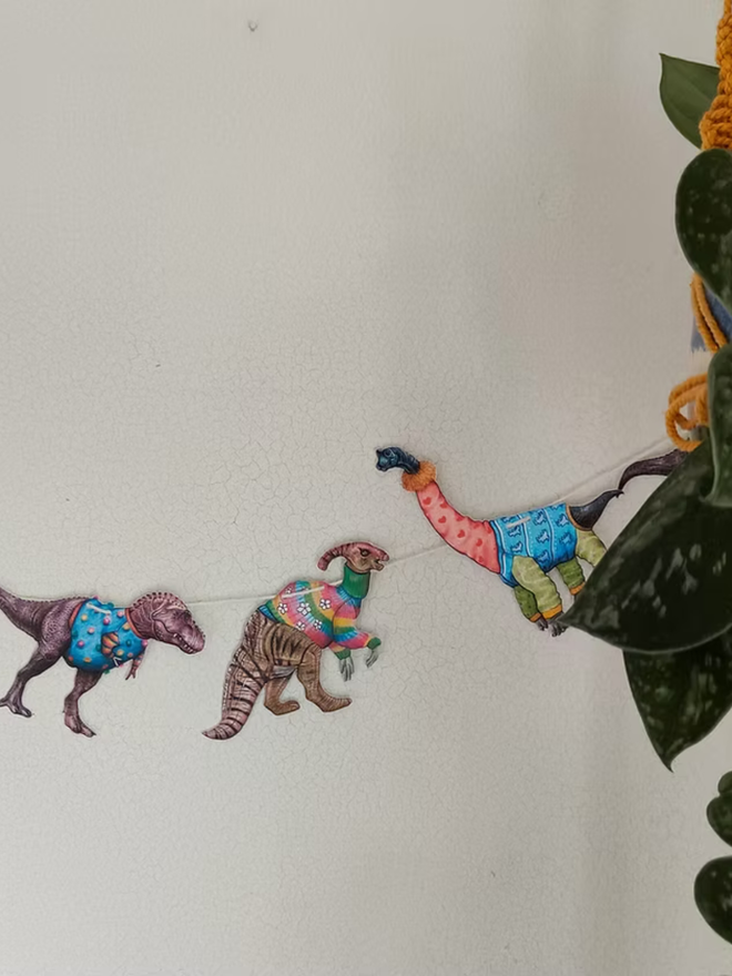 illustrated dinosaur garland. dinosaurs wearing jumpers on bunting.