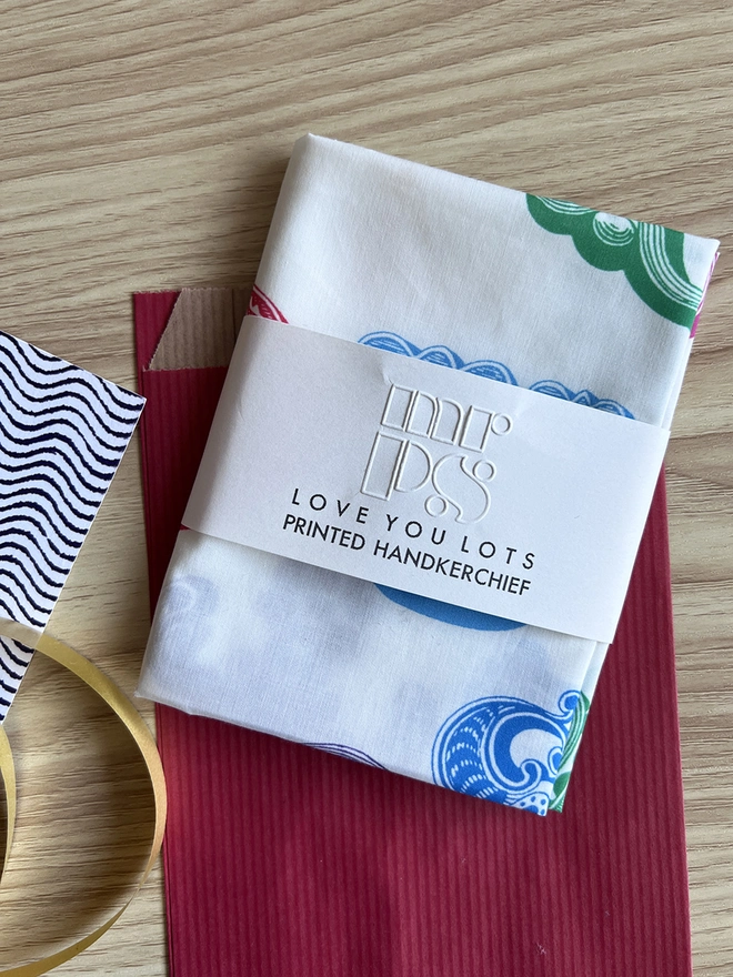 A Mr.PS Love You Lots Multicolour handkerchief folded on a wooden table