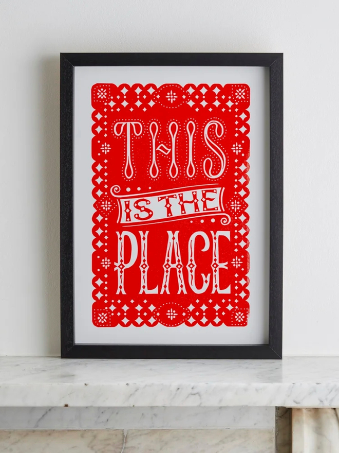 this is the place linocut. a linocut phrase printed with red paint.