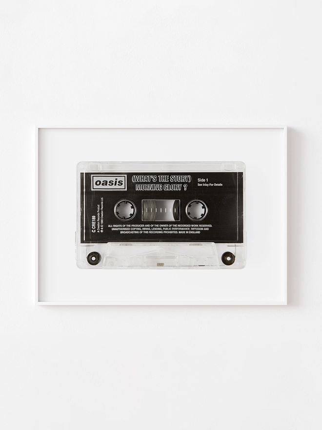 oasis whats the story morning glory cassette tape print. framed print hung up on white wlal.