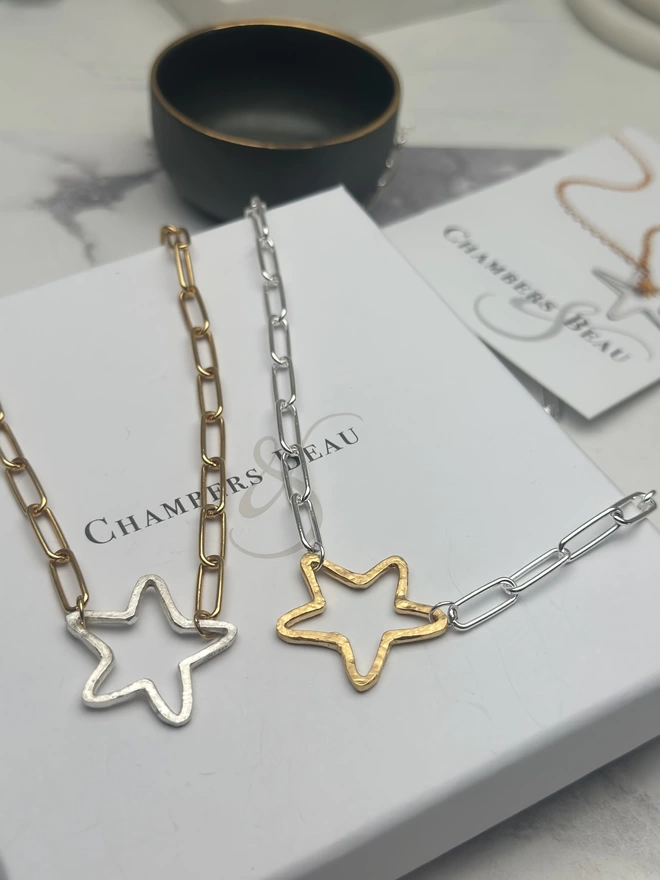 rough hewn open star charm in gold on a sterling silver paperclip chain and rough hewn sterling silver open star charm on gold paperclip chain with gift box