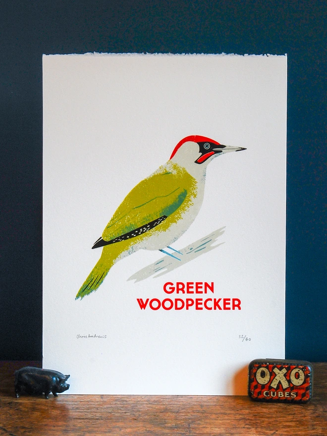 illustrated green woodpecker print. green woodpecker print propped up against navy blue background.