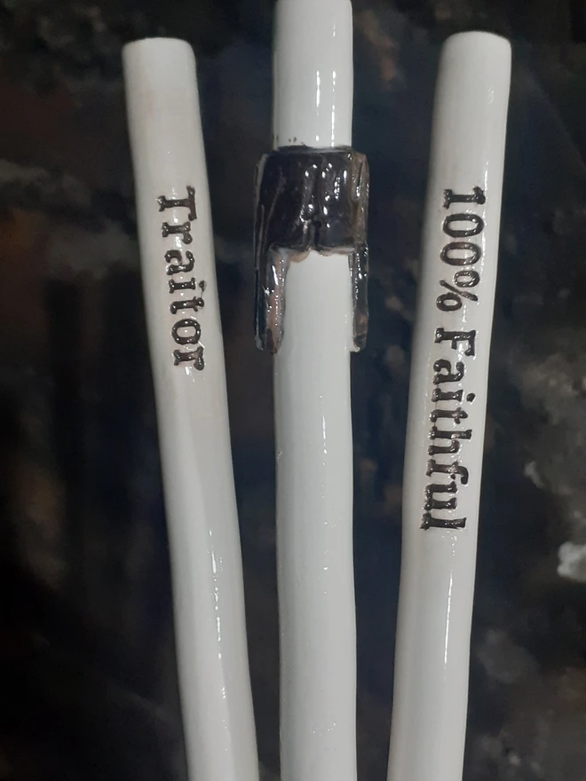 Close-up of a fan-made Claudia Winkleman–inspired ceramic drinking straw set, showing raised black lettering and a wrapped fringe detail on a white ceramic straw.