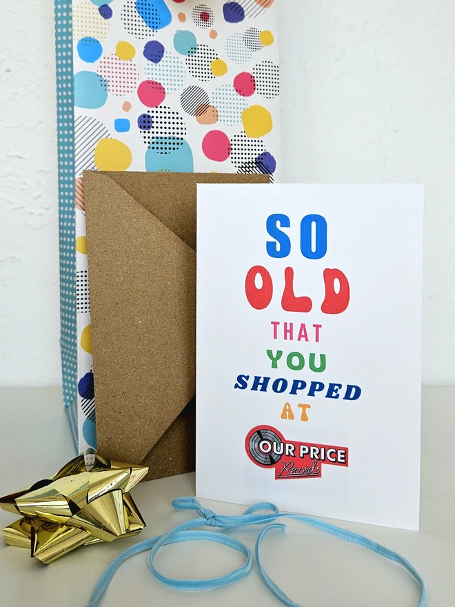 A photograph of the front of a humorous A6 greeting card illustrated using brightly coloured text and the retro shop logo. The text says so old you shopped at OurPrice.