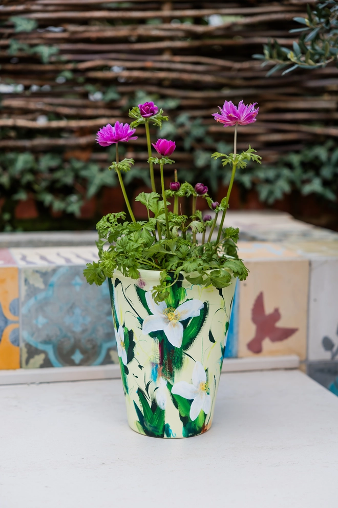 Hand-painted terracotta plant pot featuring white clematis flowers on a pale green background  