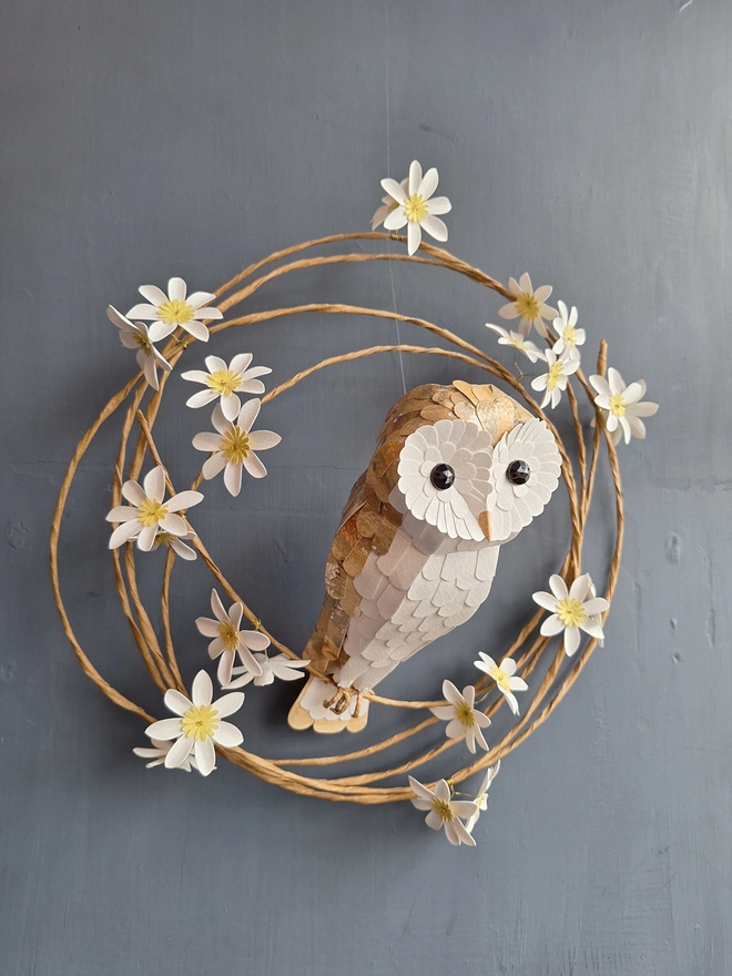 Handmade barn owl sculpture perched on a wreath of white flowers
