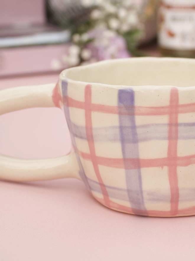 close up of pink and purple gingham stripes on stoneware mug