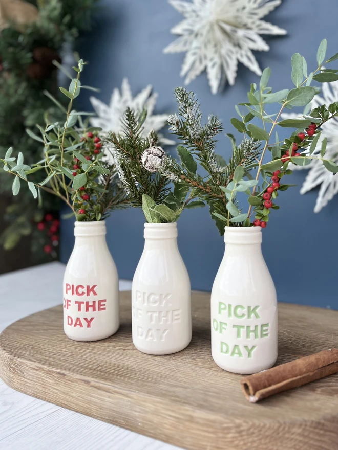 Three pick of the day bottle filled with Christmas foliage