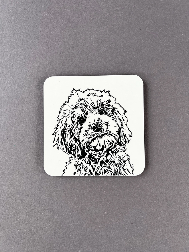 Melamine coaster illustrated with the face of a fluffy cockapoo puppy