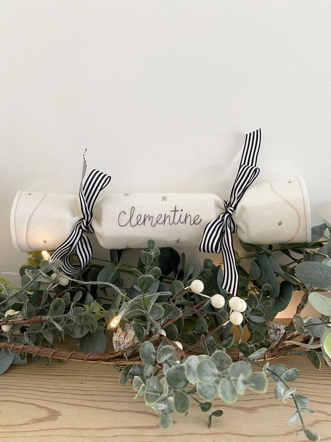 Personalised Christmas Cracker on a mantlepiece with leaves