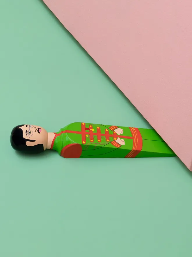 Wooden Door Stopper (Lenny), a colourful wooden door stop sitting under a door.