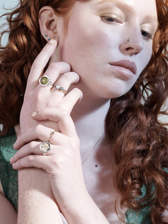lifestyle, model wearing silver highlights scorpio hand ring amongst a mix of others