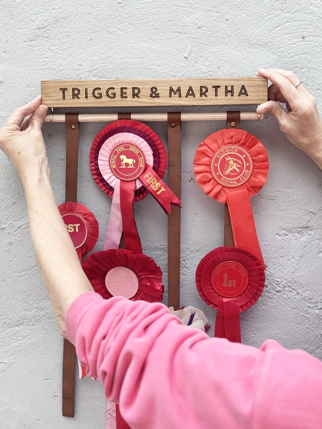 oak wooden rosette holder against a grey wall with red rosettes on it by modo