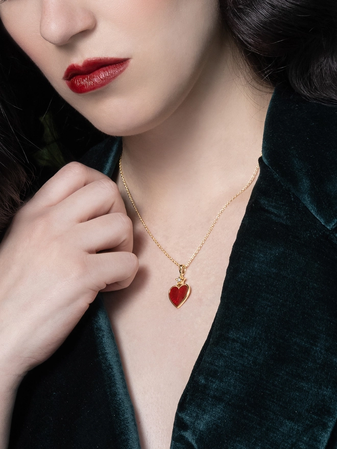 Model wearing red enamel heart necklace on gold chain