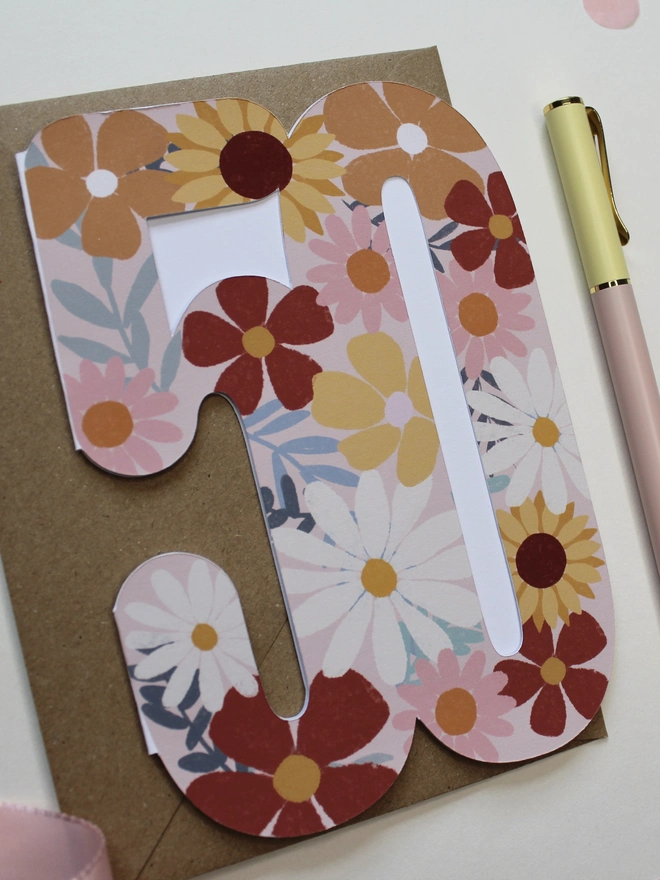 floral 50th birthday card. card shaped like 50 decorated with colourful flowers.