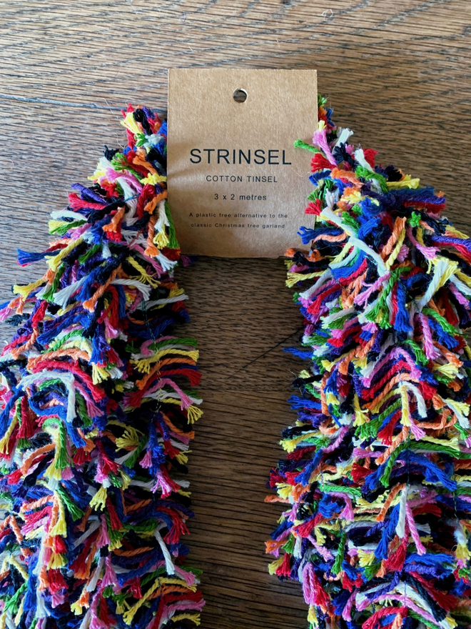 Multipack of Rainbow Strinsel (plastic free mulitcolour string tinsel) on an oak table