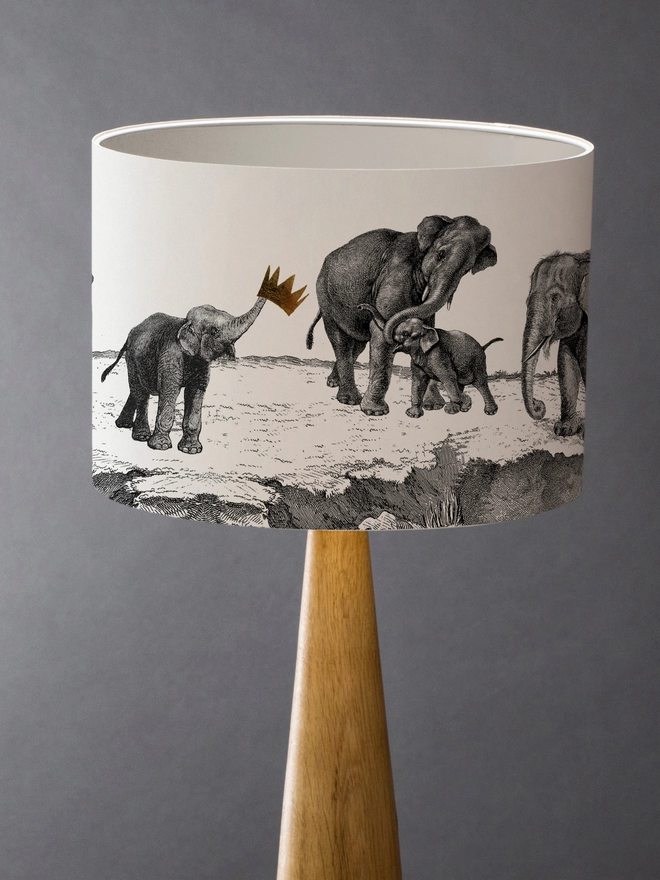 Drum Lampshade featuring elephants with a white inner on a wooden base 
