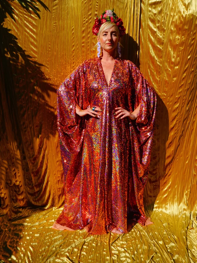Rose Gold Holographic Sequin V-neck Kaftan Gown seen on a woman with her hands on her hips.
