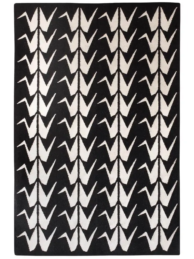 Crane Flatweave Rug, a colourful rug sitting on a plain surface. 