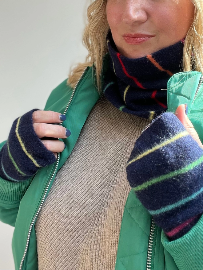 Navy knitted snood with colourful thin stripes being worn with matching wristwarmers