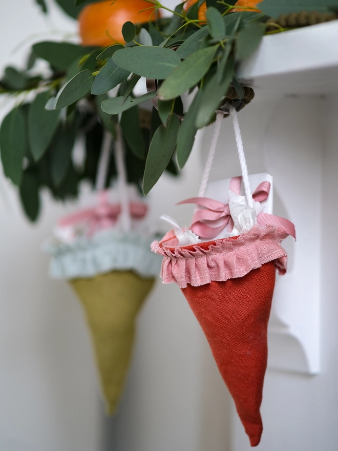 Reusable Victorian Christmas gift cones for hanging beneath festive greenery, featuring delicate ruffled trim.