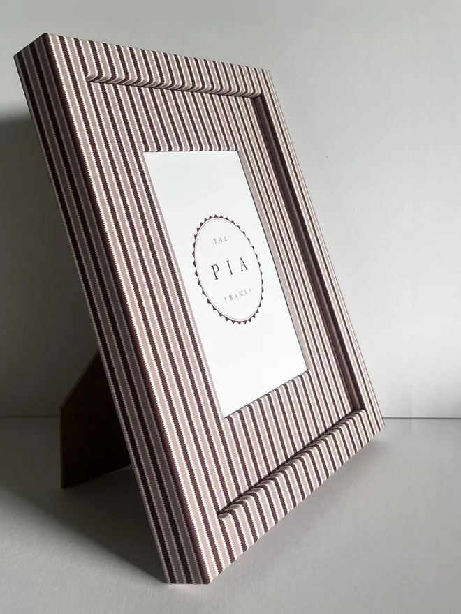 Blush & Burgundy Zigzag Frame, a colourful striped frame sitting on a plain white surface. 