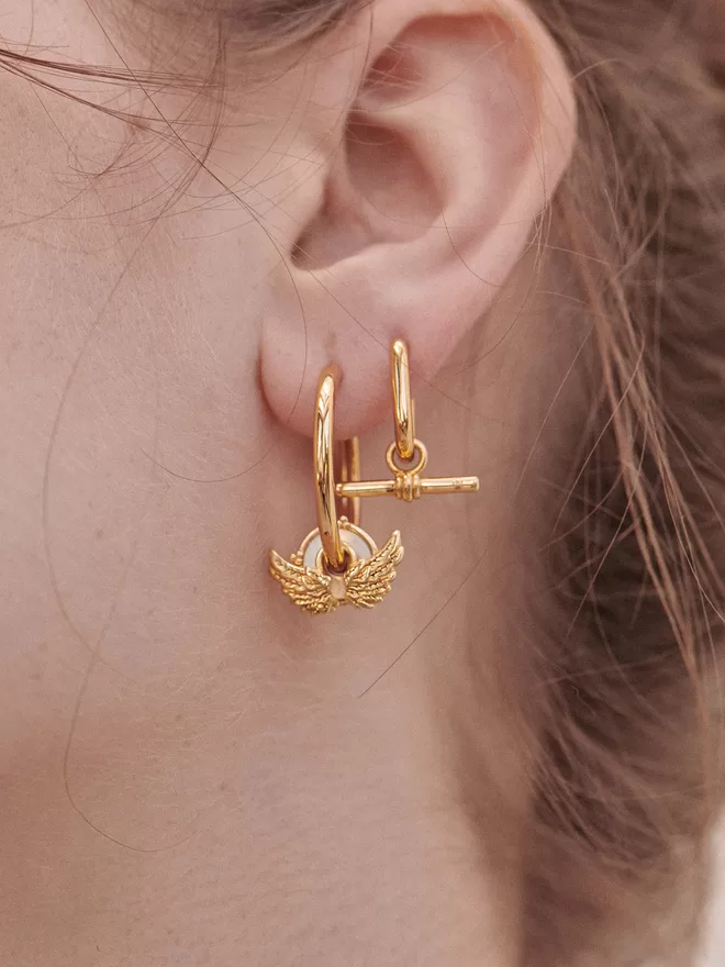 woman wearing gold earrings with charms