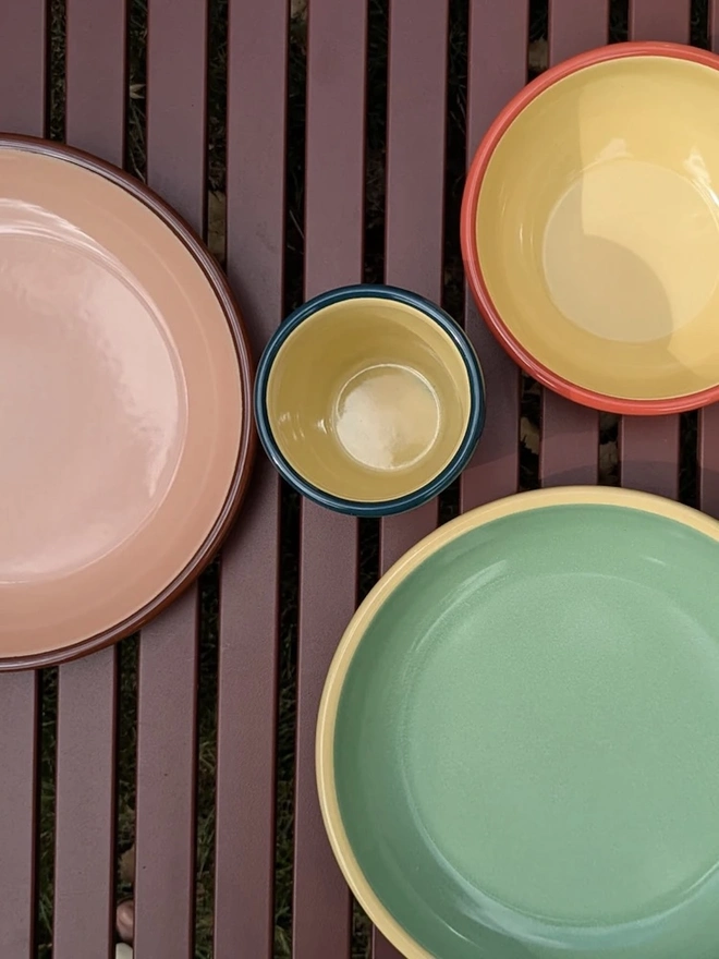 Enamel Plate, a collection of enamelware sitting on a wooden surface. 