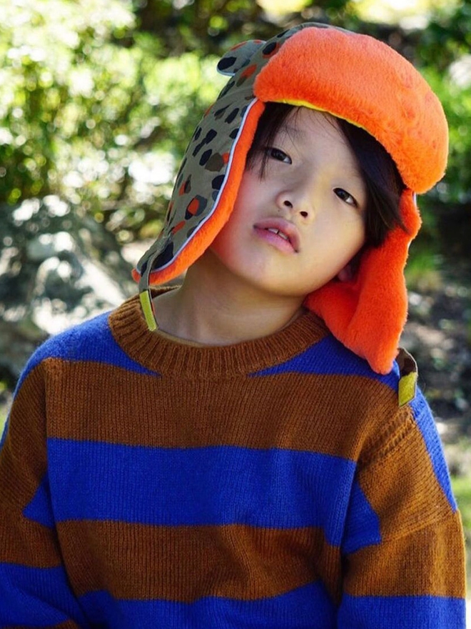 Boy wearing winter neutral leopard trapper hat