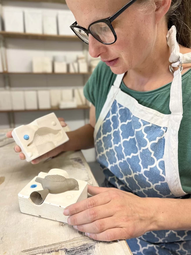 Katie had just lifted up part of a plaster mould revealing a freshly cast bird handle in clay.