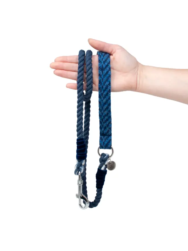 navy rope dog lead held in a hand on white background