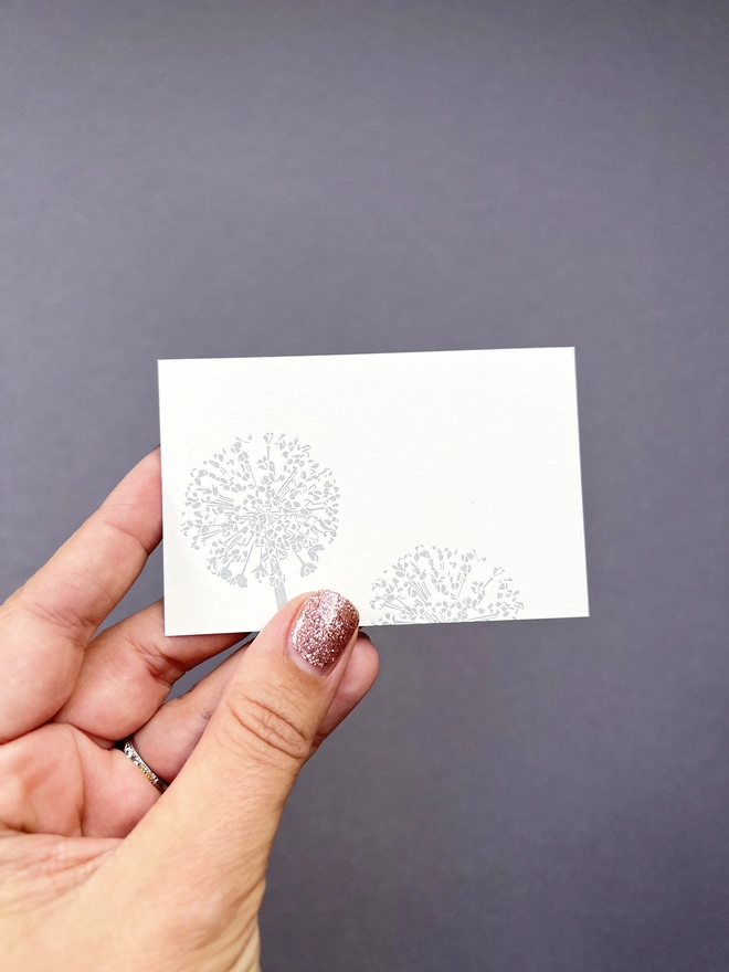 A hand holding the Allium tiny note.