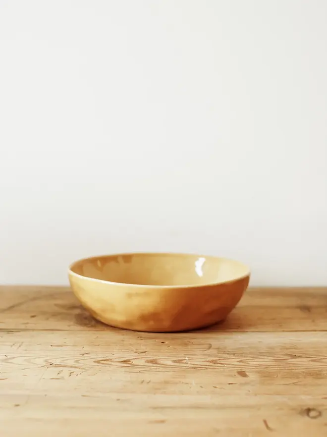 'dijon' handcrafted stoneware serving bowls. a medium yellow serving bowl.