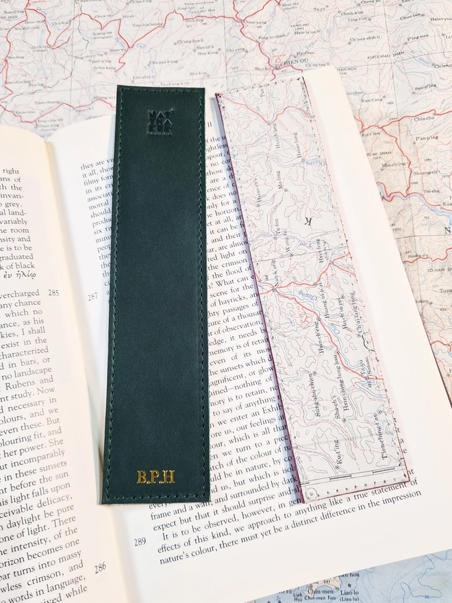 A forest green ethically produced vegetable tanned Italian leather bookmark lined with an original silk escape map from the Cold War personalised with gold foil initials with the initials B and P and H by natthakur on a map of Kweilin in China