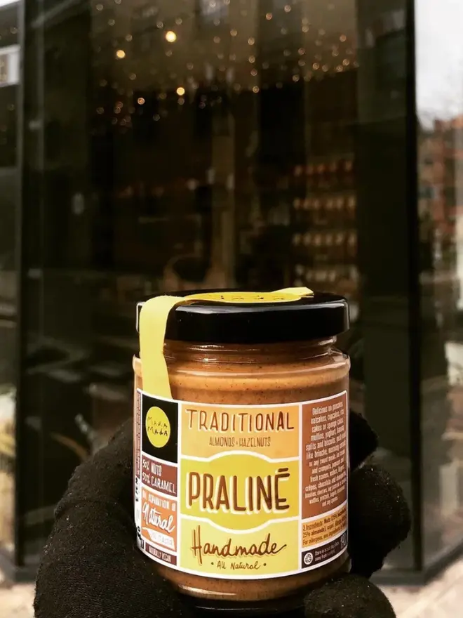 Almond & Hazelnut Praline Spread, held in a glove. 