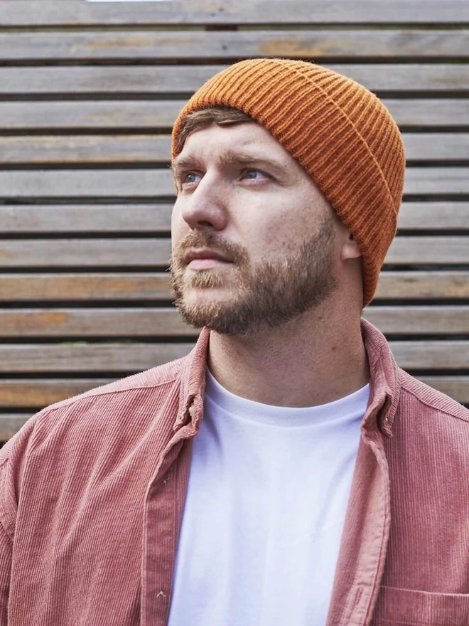 Ribbed Lambswool Men's Beanie, a person wearing a colourful ribbed beanie outdoors. 