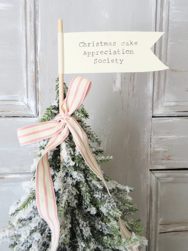 Organic cotton flag hand painted with festive message wrapped around a wooden dowel
