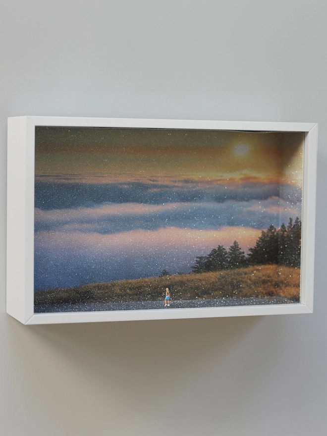 TIny figure of a young woman looking out from a hill overlooking the beautiful sunset through clouds (whole artwork)
