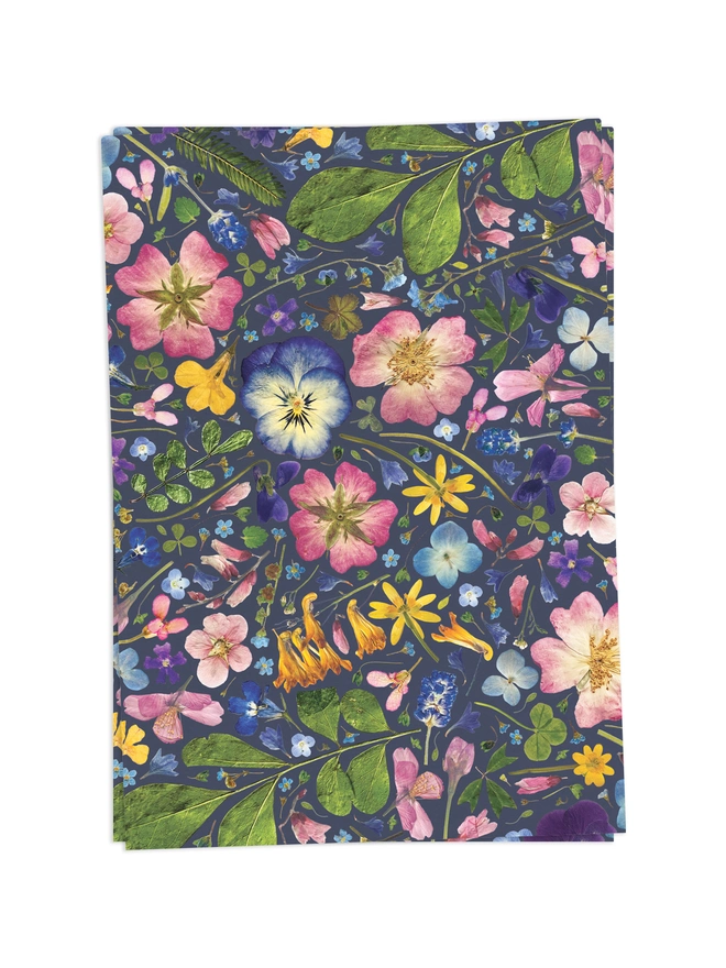 2 Folded wrapping paper sheets with a floral design created from pressed flowers.