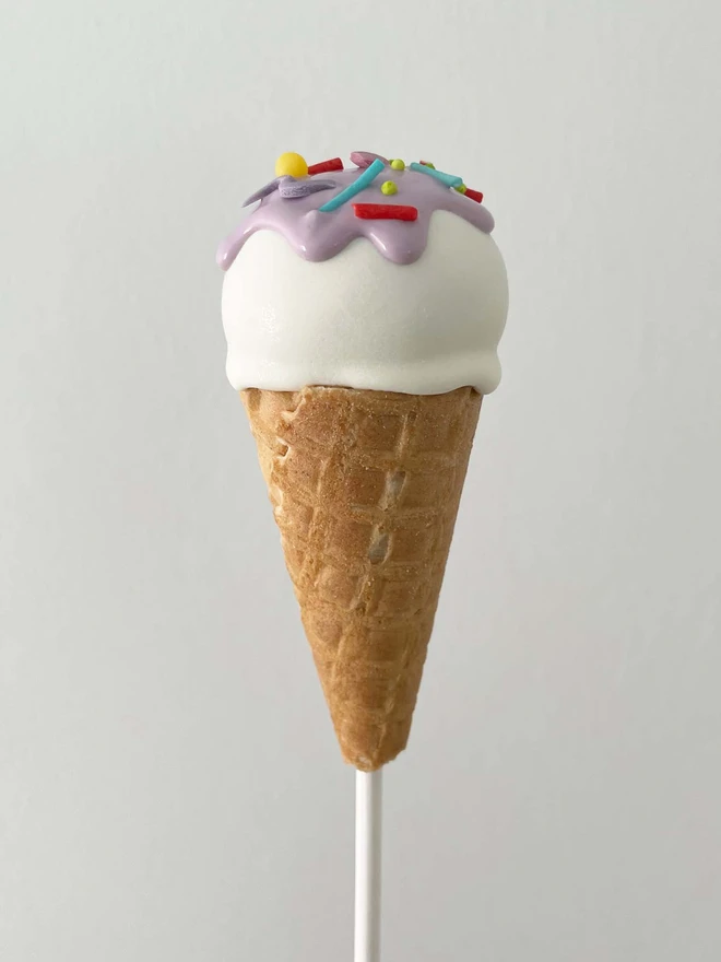 Ice Cream Cake Pops (Pack Of 6, 12, 18, 24), ice cream cake pop placed against a plain background. Multi-coloured sprinkles on top of the cake pop.
