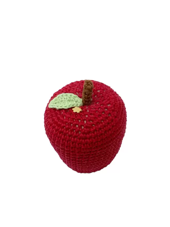 Cut out image of a red crochet apple with a plain background.