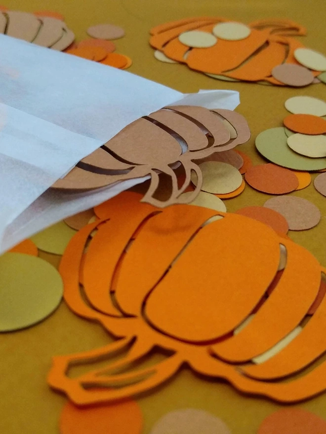 Closeup view of orange and cinammon lasercut pumpkin confetti decorations