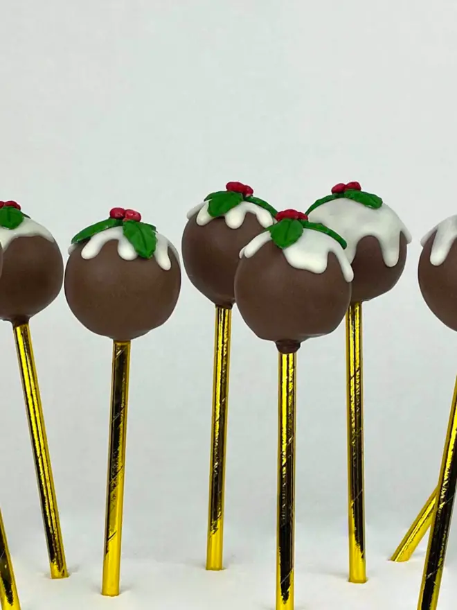 Christmas Pudding Cake Pops (Pack of 6, 12, 18, 24)  in a white chocolate drip and topped with holly made from fondant.