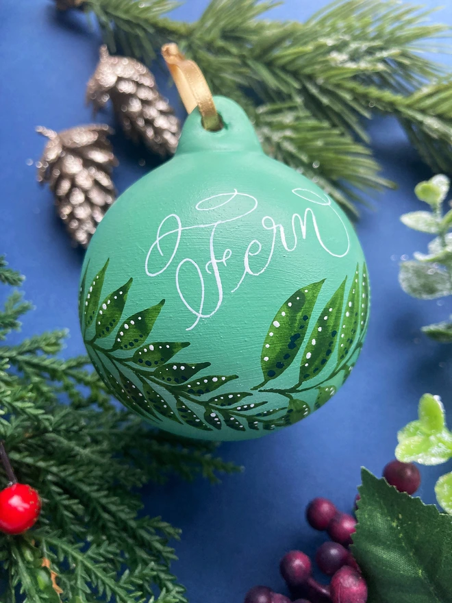 Green fern Christmas bauble hand painted with calligraphy name