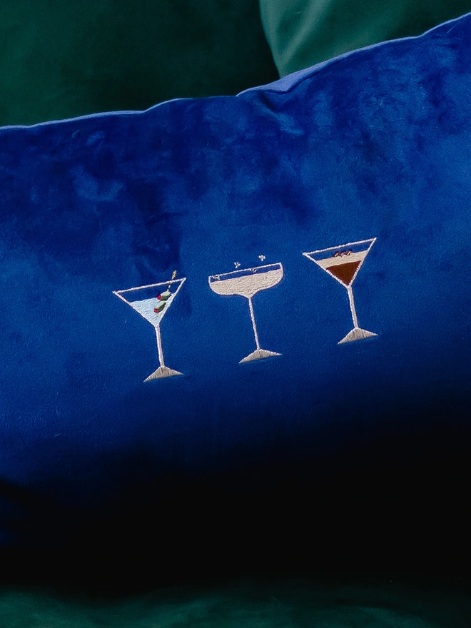 CLose up of the cocktail embroidery on a navy velvet background