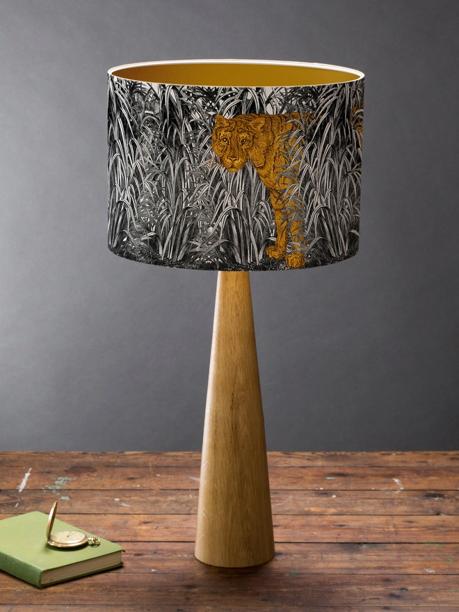 A decorative lampshade featuring an elegant tiger moving through tall tropical grasses, inspired by Henri Rousseau’s jungle paintings, with a rich botanical design.
