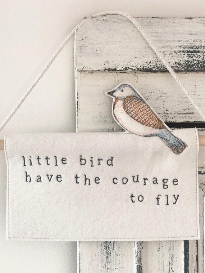 little bird have the courage to fly felt banner hung on door frame