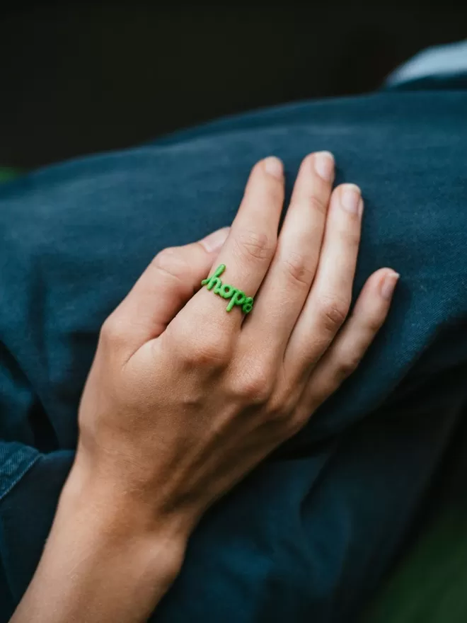 'Hope' Ring Original seen in green on a hand.