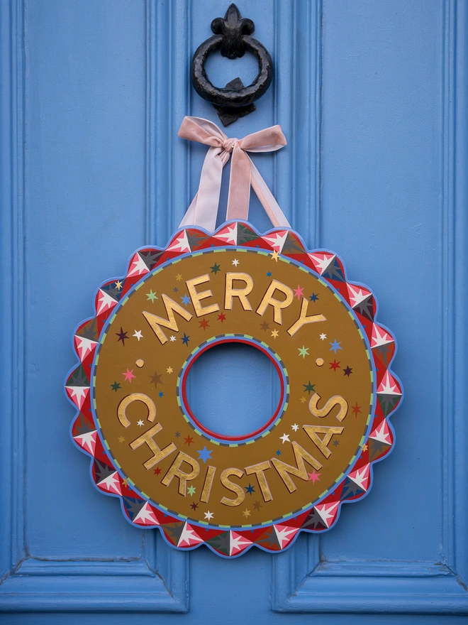 Multicoloured Hand painted Christmas Wreath with gold leaf lettering on a blue front door