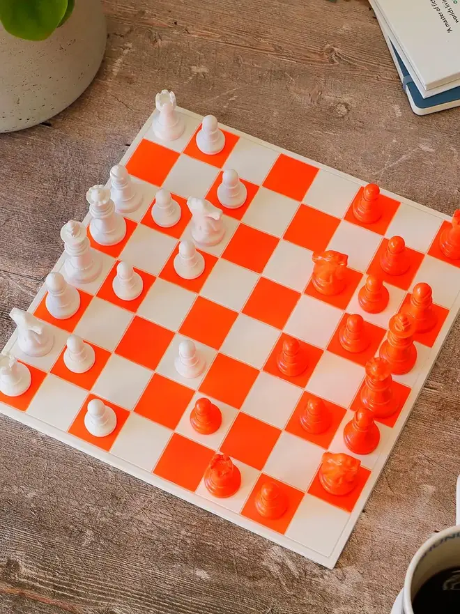 Handmade Jesmonite Chess Board, a handmade colourful chess board sitting on a wooden surface. 